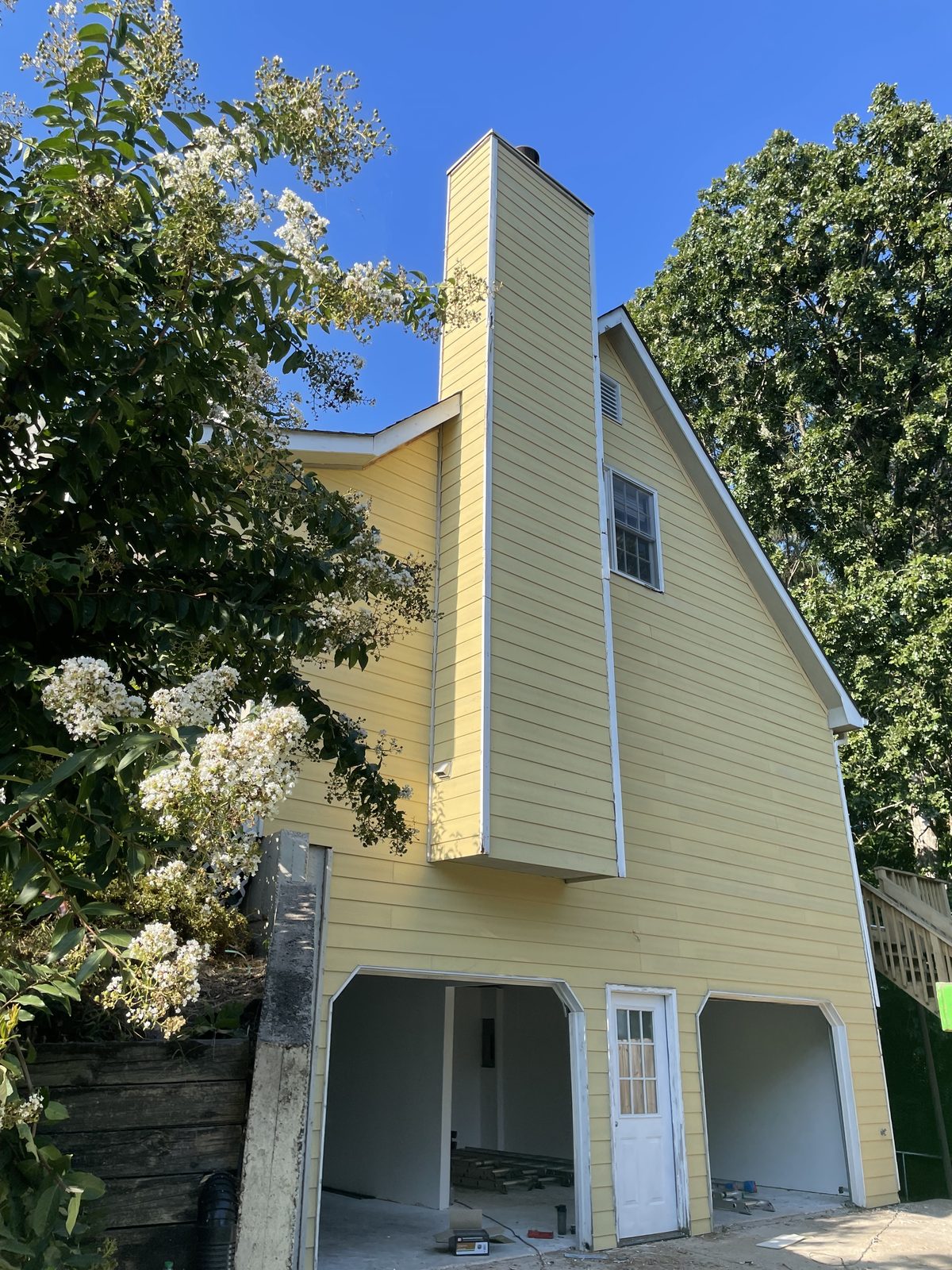 Sunlit yellow exterior house painting in Northern Virginia