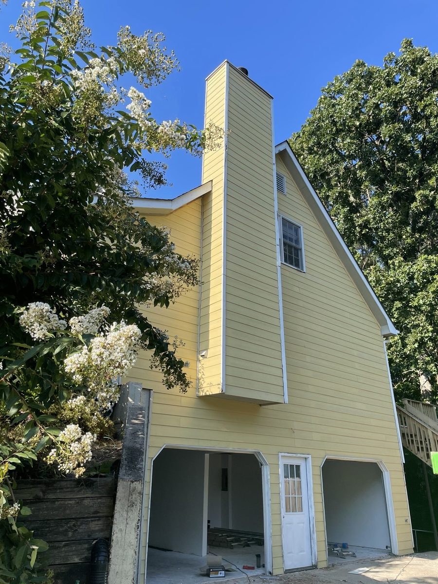 Yellow exterior house repaint with new chimney siding in Northern Virginia